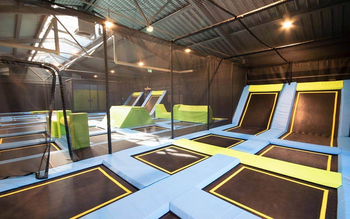 Trampolinbereich im Stuntwerk Trostberg mit mehreren Sprungflächen, Schrägtrampolinen und weichen Polsterflächen. Helle Indoor-Halle für sicheres, spielerisches Springen und Bewegungsspaß für Kinder, Jugendliche und Erwachsene.